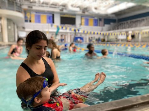 Swim Guard Jenna Isa teaches a child how to swim - Courtesy of Nataniel Zoladek